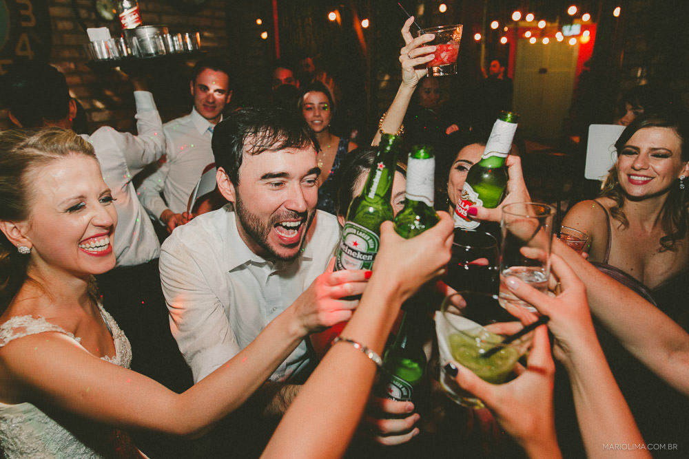 Noivos brindando com familiares em festa de casamento no Espaço Quintal