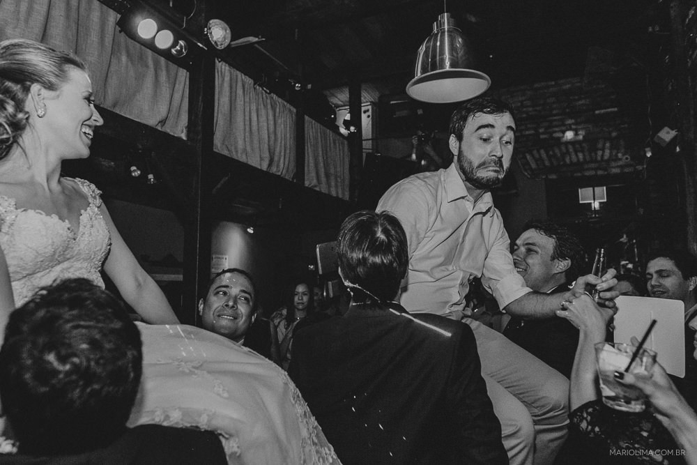 Noivos no colo dos convidados em festa de casamento no Espaço Quintal