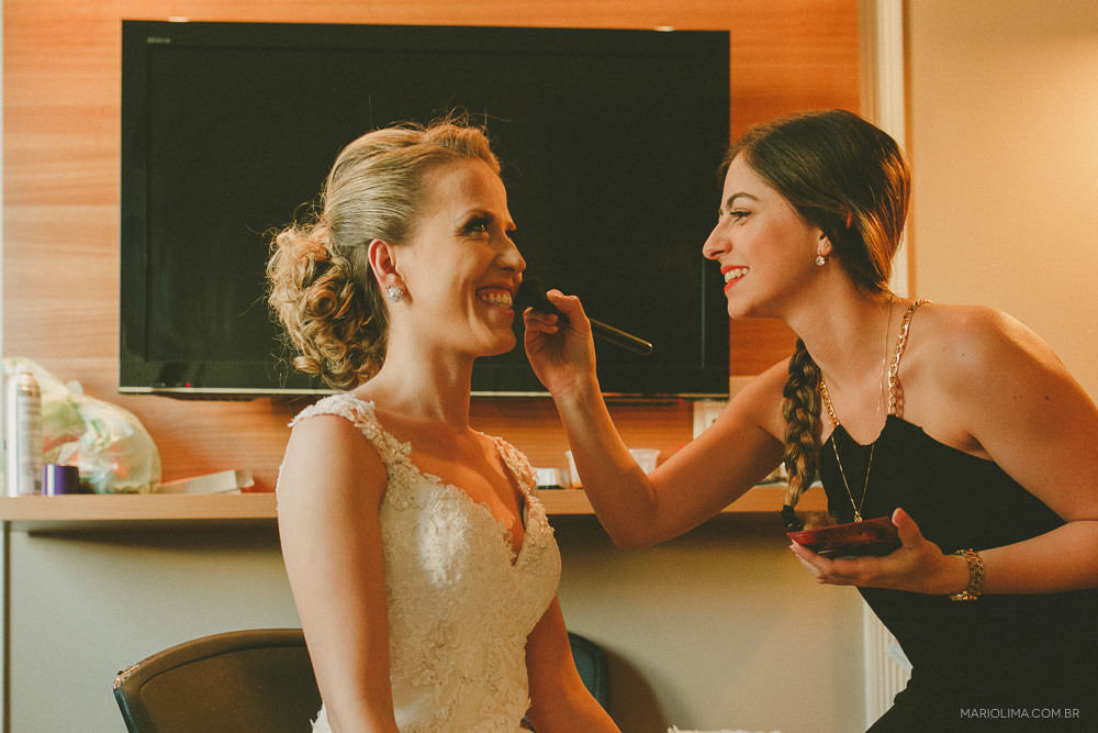 Noiva sorrindo ao ser maquiada no Hotel The Universe Flat