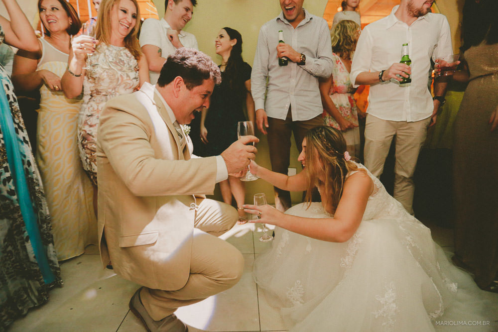 Noivos dançando com champagne na mão em festa de casamento no Pier 151 em Ilhabela