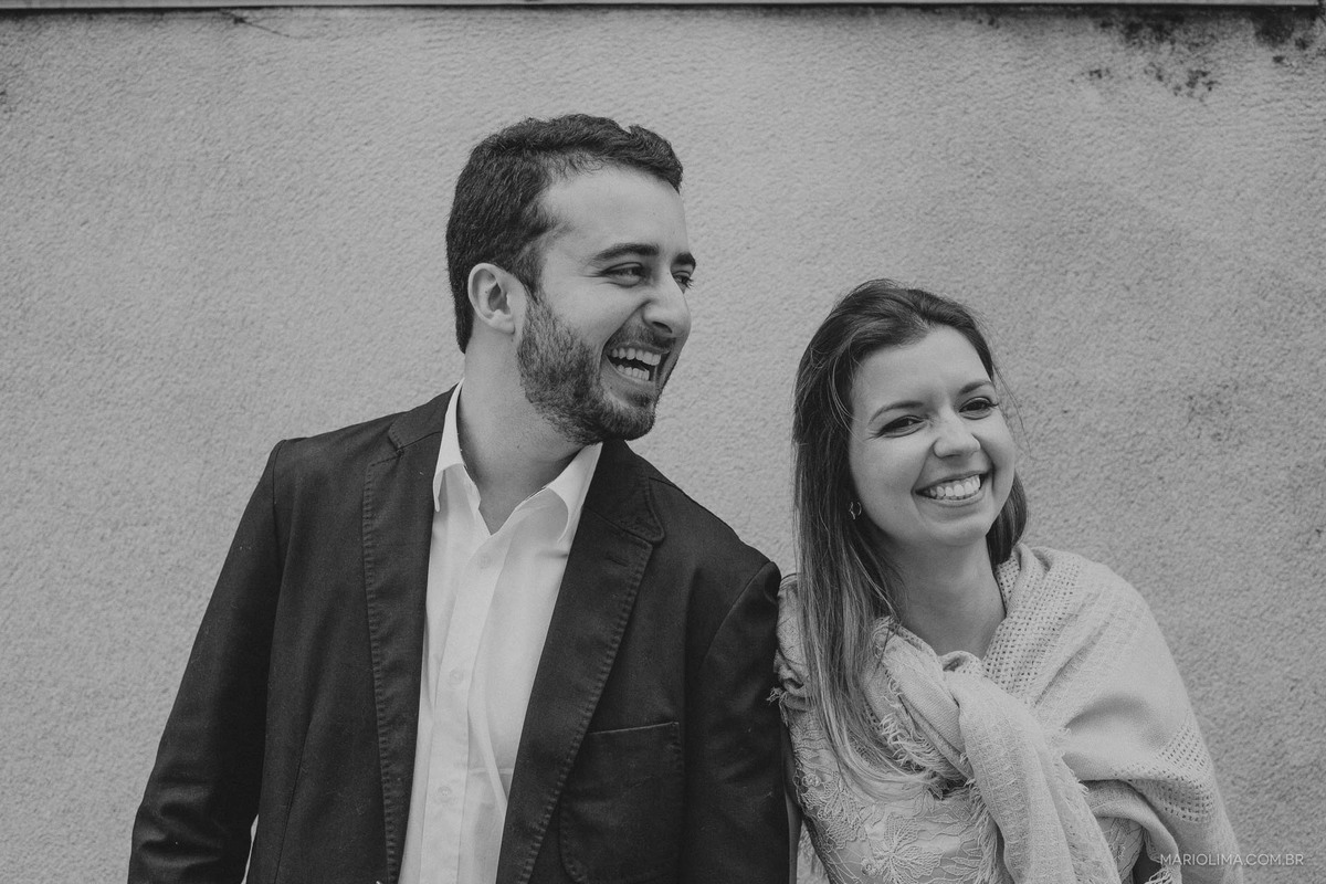 Noivos de mãos dadas sorrindo em Edifício Martinelli no centro histórico de São Paulo.