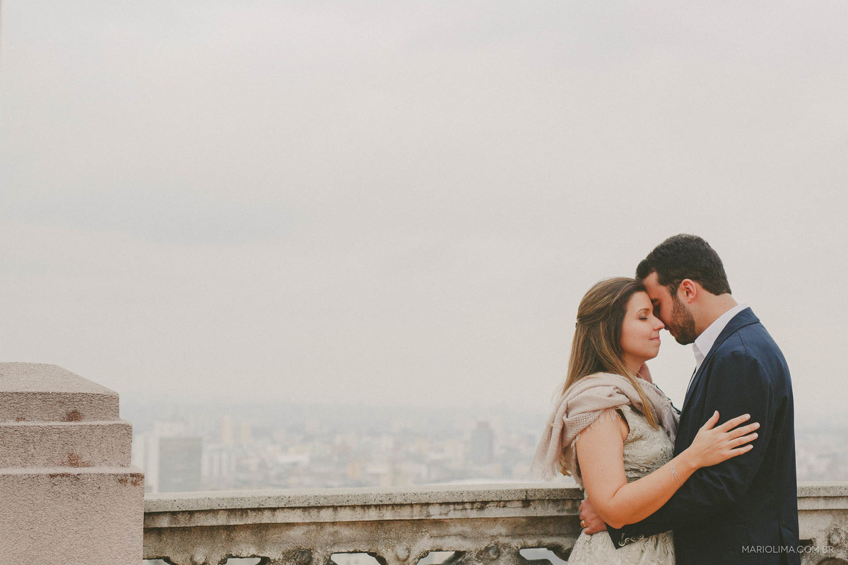 Noivos abraçados de olhos fechados em Edifício Martinelli no centro histórico de São Paulo.