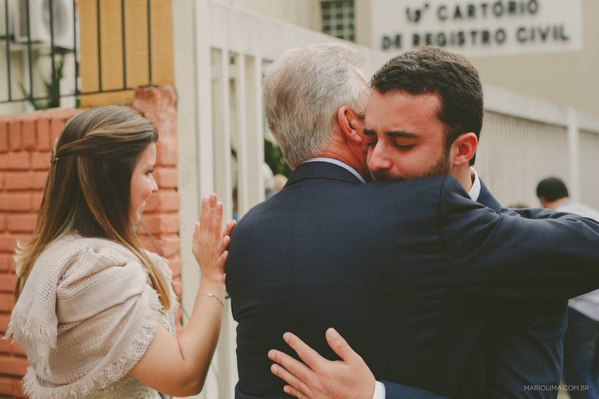 Noivo cumprimentando o pai em frente ao cartório