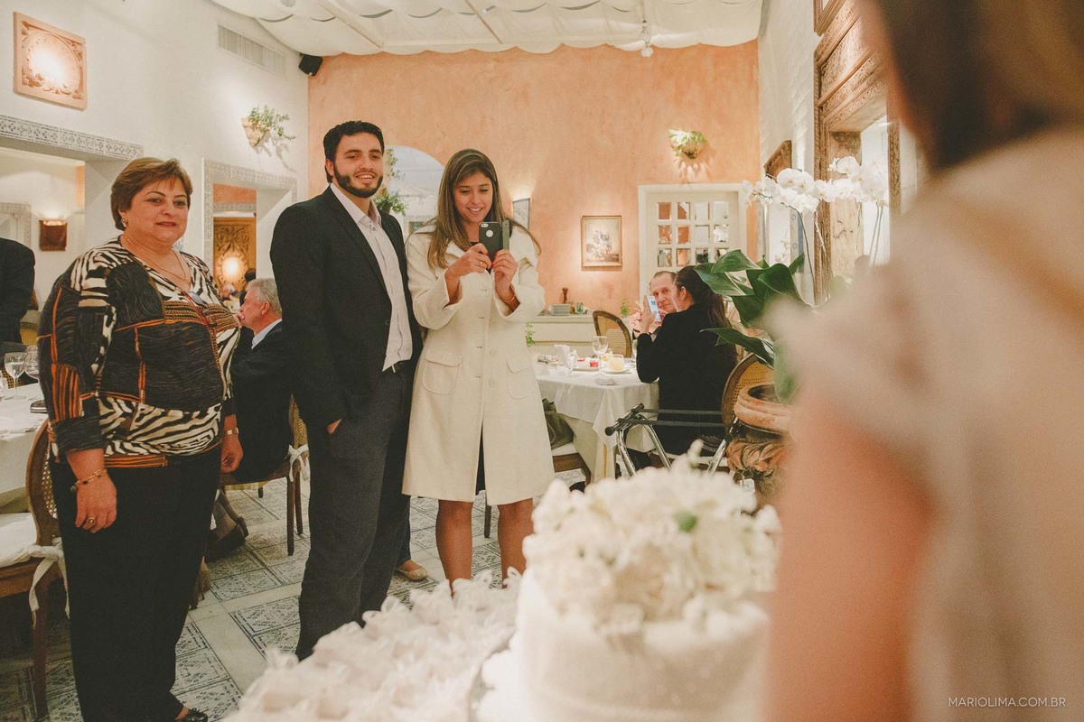Familiares vendo os noivos na mesa do bolo em Restaurante La Tambouille
