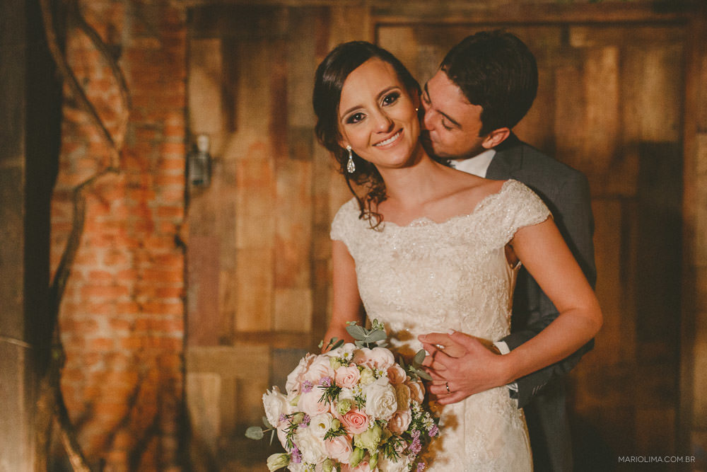 Noivo beijando o pescoço da noiva em Manioca