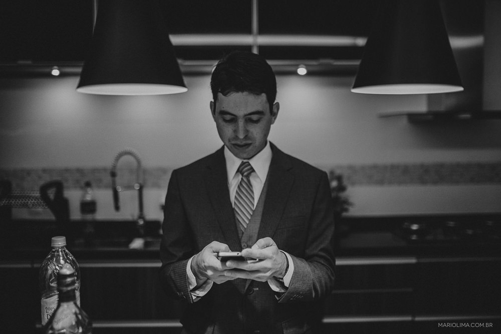 Fotografia de noivo mexendo no celular