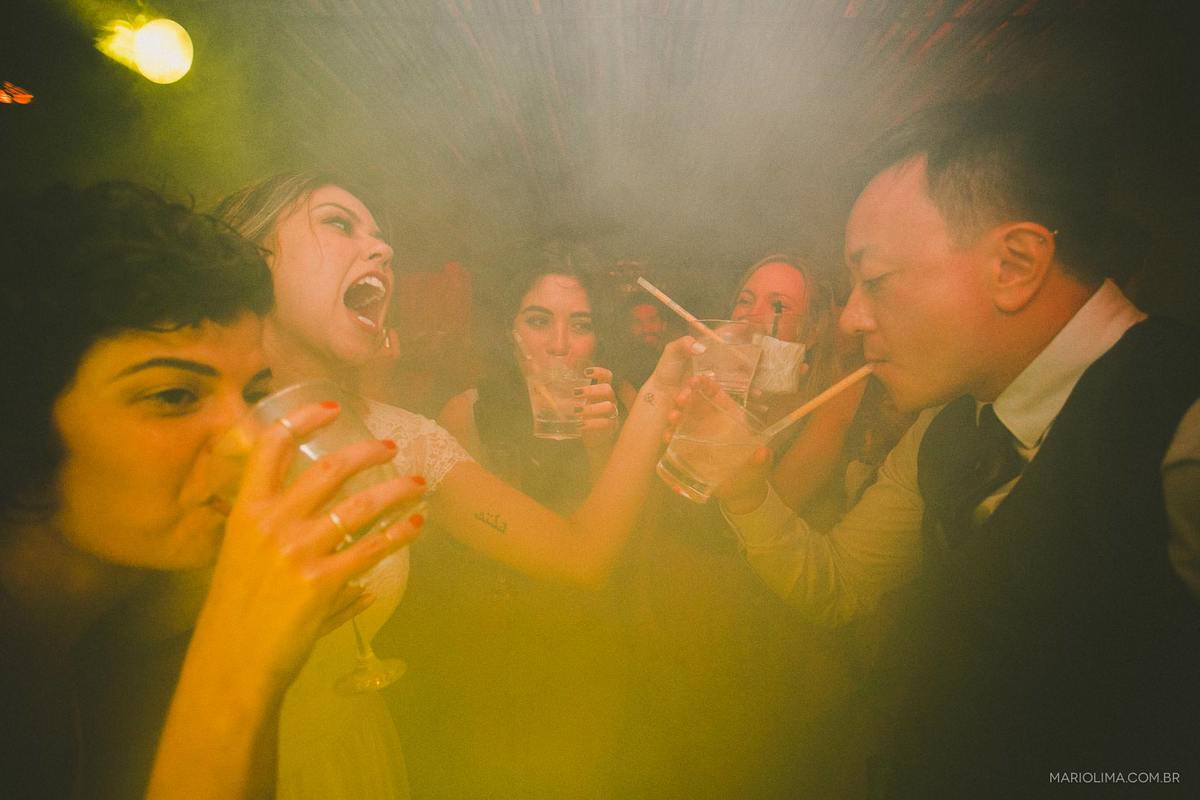 Noivos bebendo com convidados em festa de casamento em Camburi