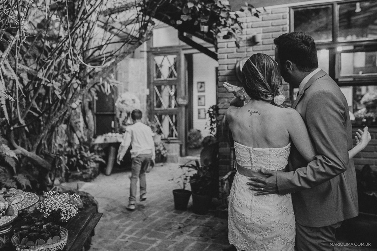 Noivos abraçados vendo criança em festa da casamento na Quinta da Cana