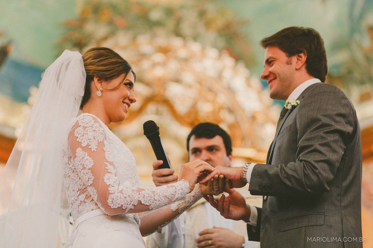 Noiva colocando aliança no dedo do noivo em Igreja Nossa Senhora do Brasil