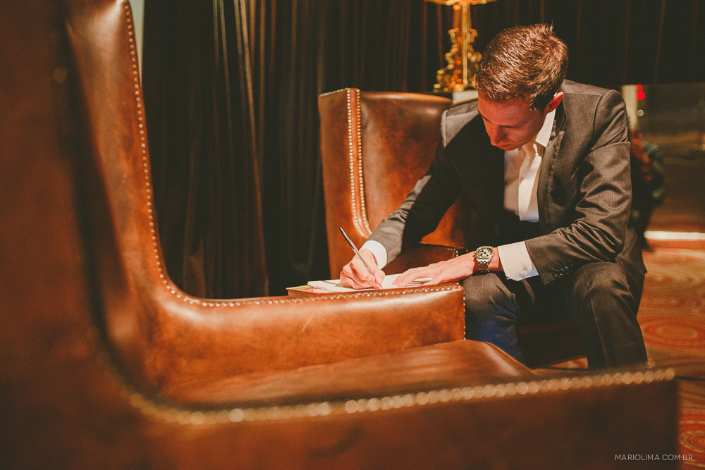 Fotografia de noivo escrevendo os votos do casamento