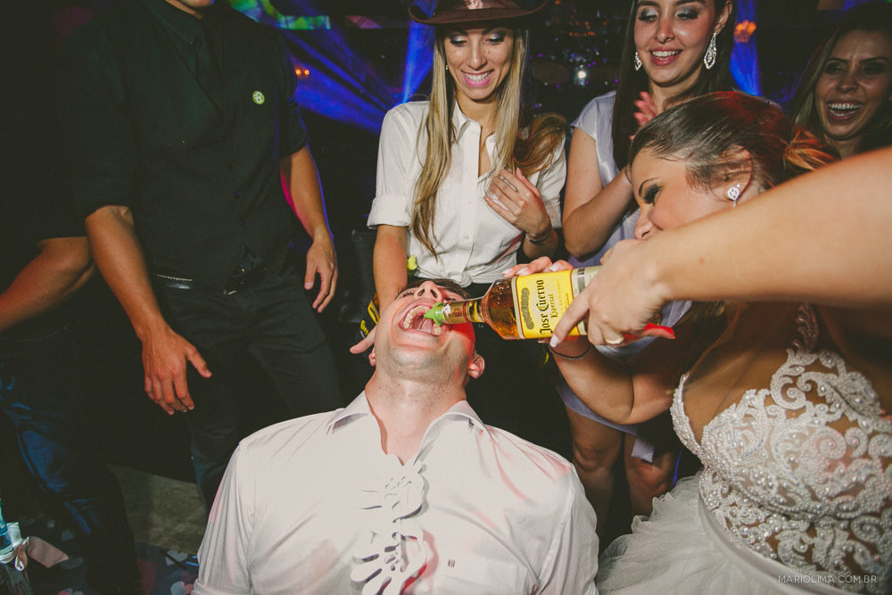 Padrinhos dando bebida para o noivo em festa de casamento na Casa Petra