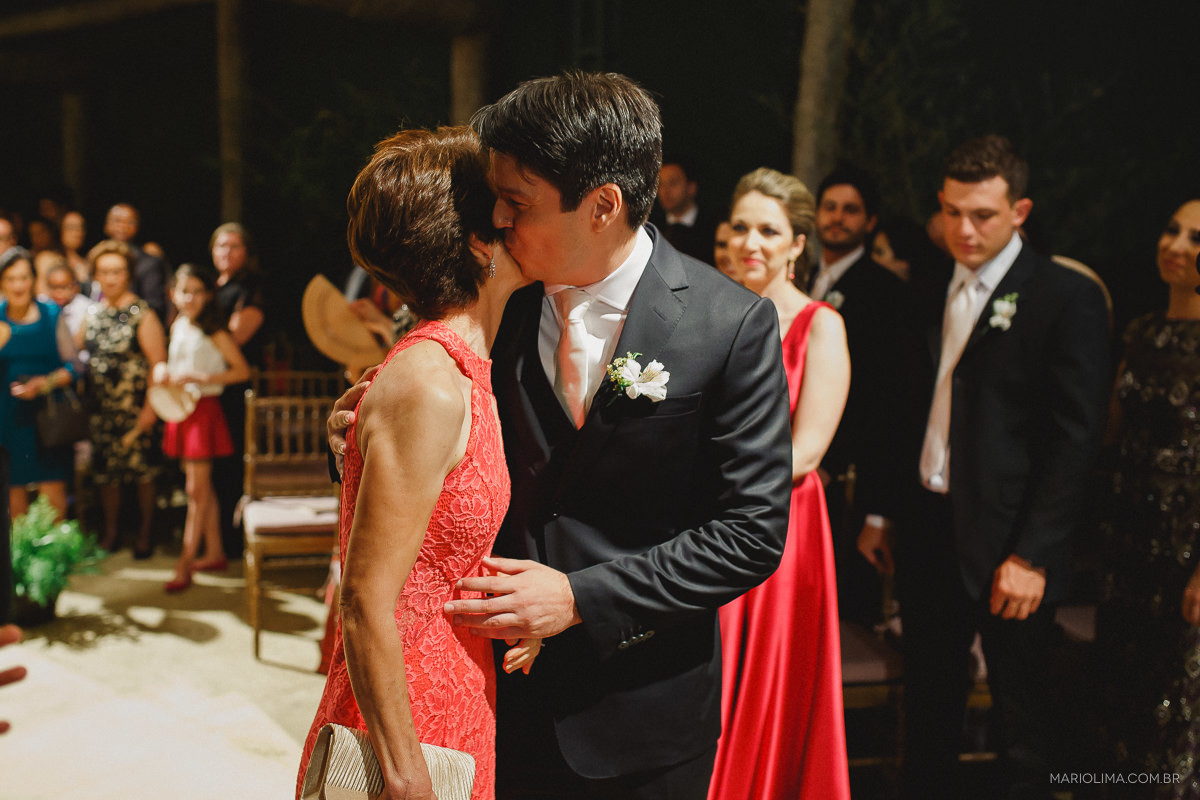 Noivo dando um beijo no rosto da mãe em cerimônia de casamento no Espaço Gardens