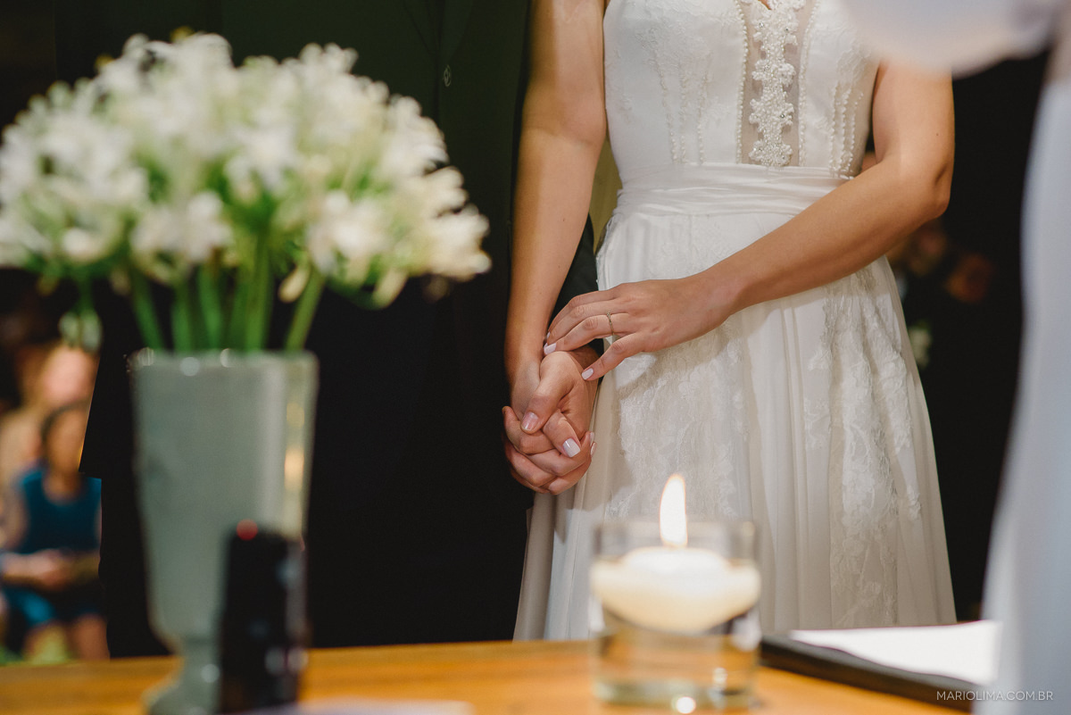Fotografia de vela e mãos da noiva