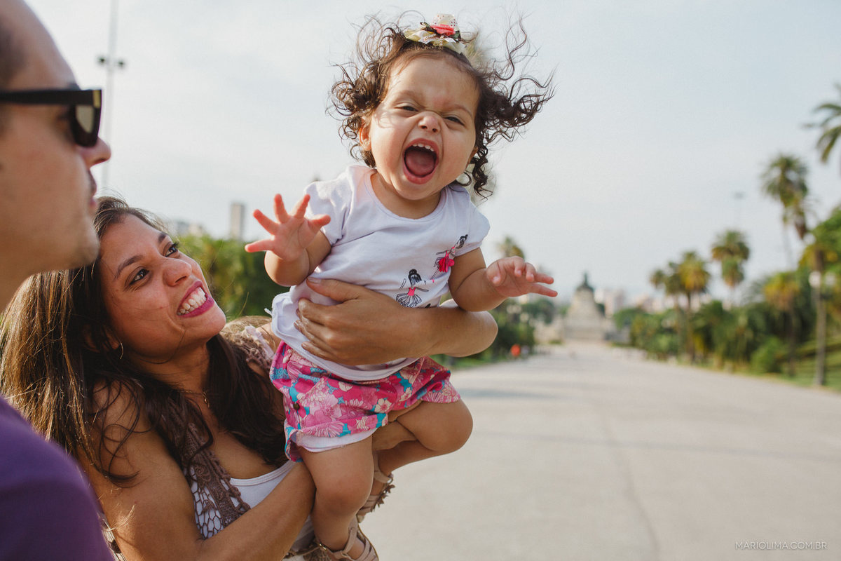 Mãe segurando filha sorridente no Parque da Independência