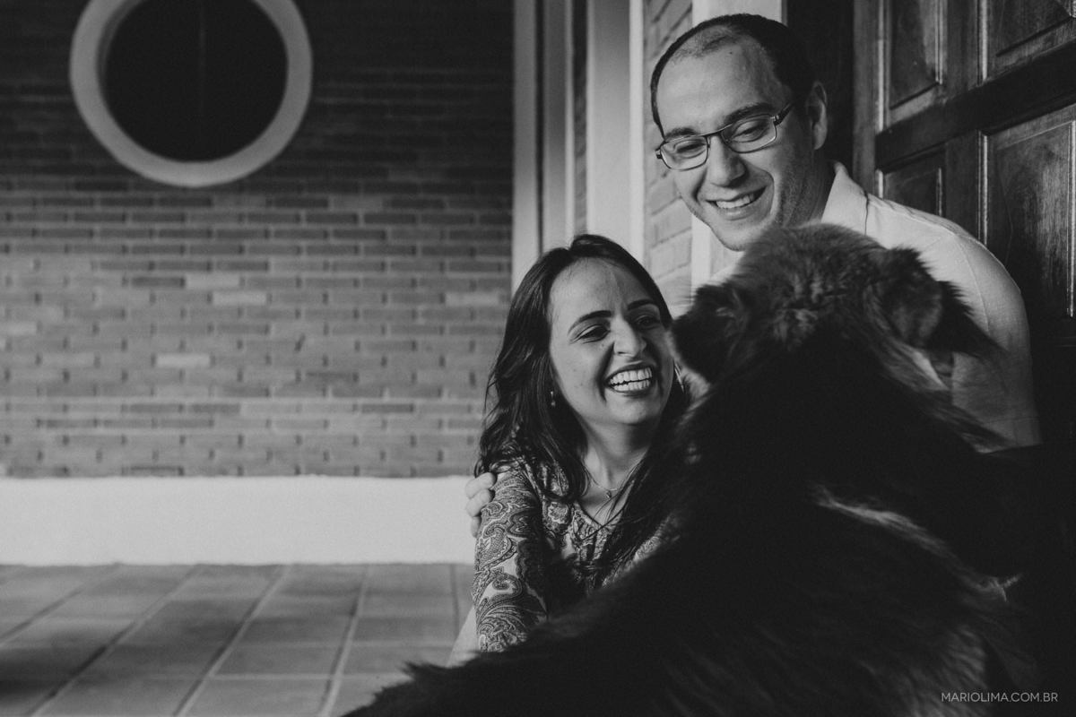 Fotografia de casal brincando com cachorro no sítio