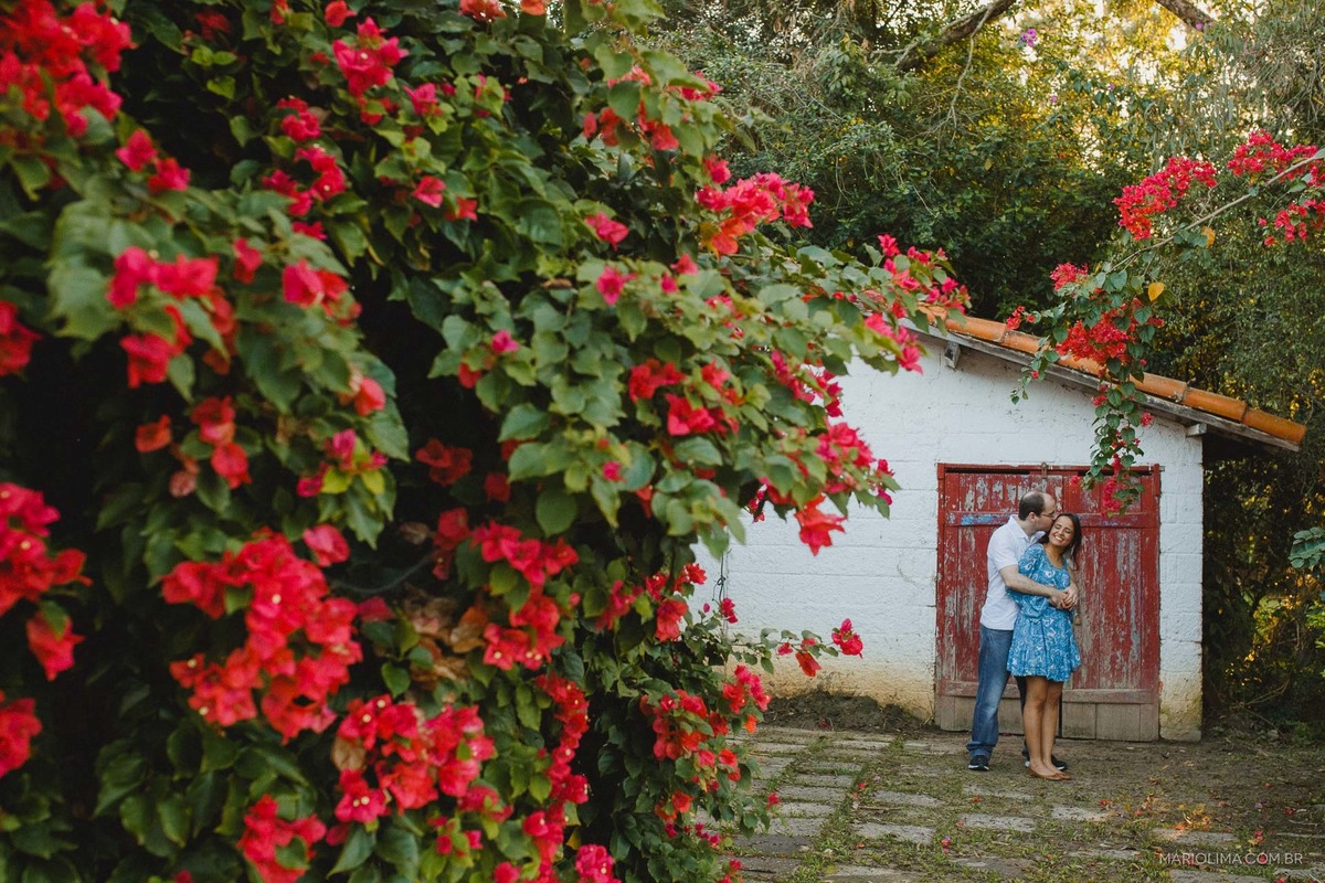 Fotografia de homem abraçando mulher em frente a casa do sítio