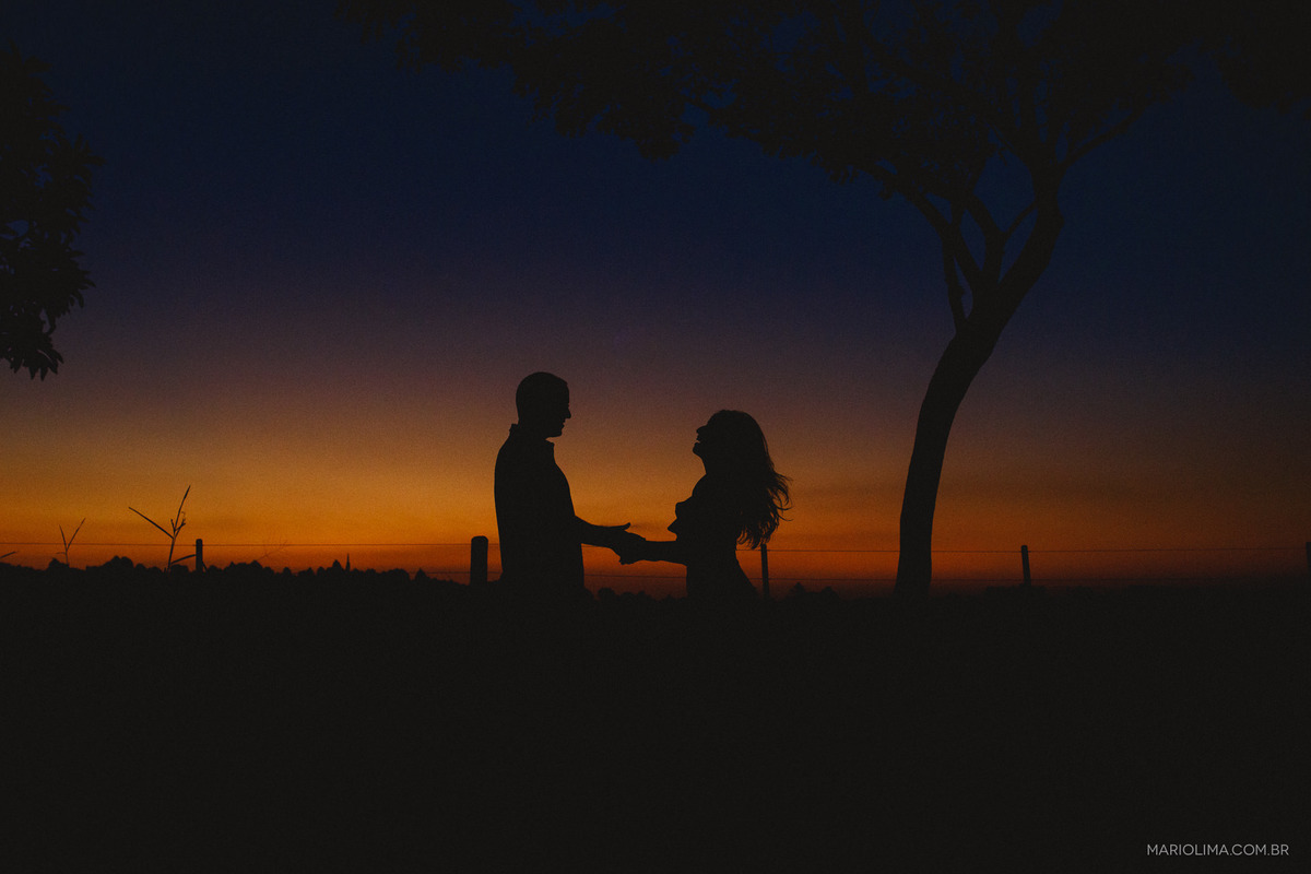 Casal de mãos dadas curtindo o pôr do sol