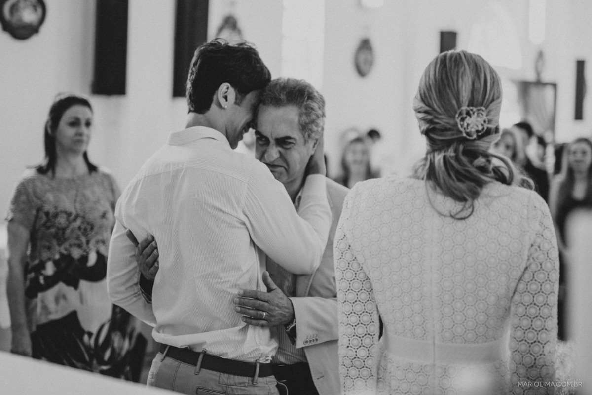 Pai abraçando noivo em cerimônia de casamento na Paróquia São Roque