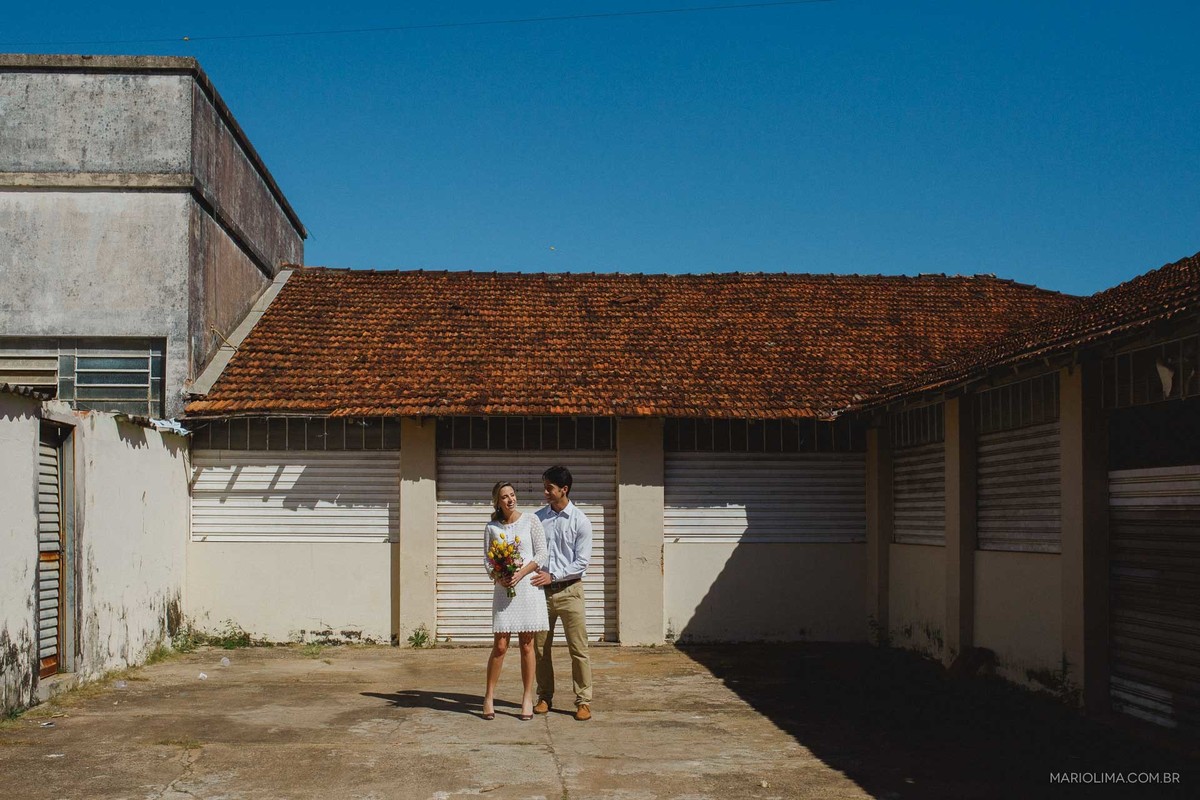 Retrato de noivos abraçados em frente a casa