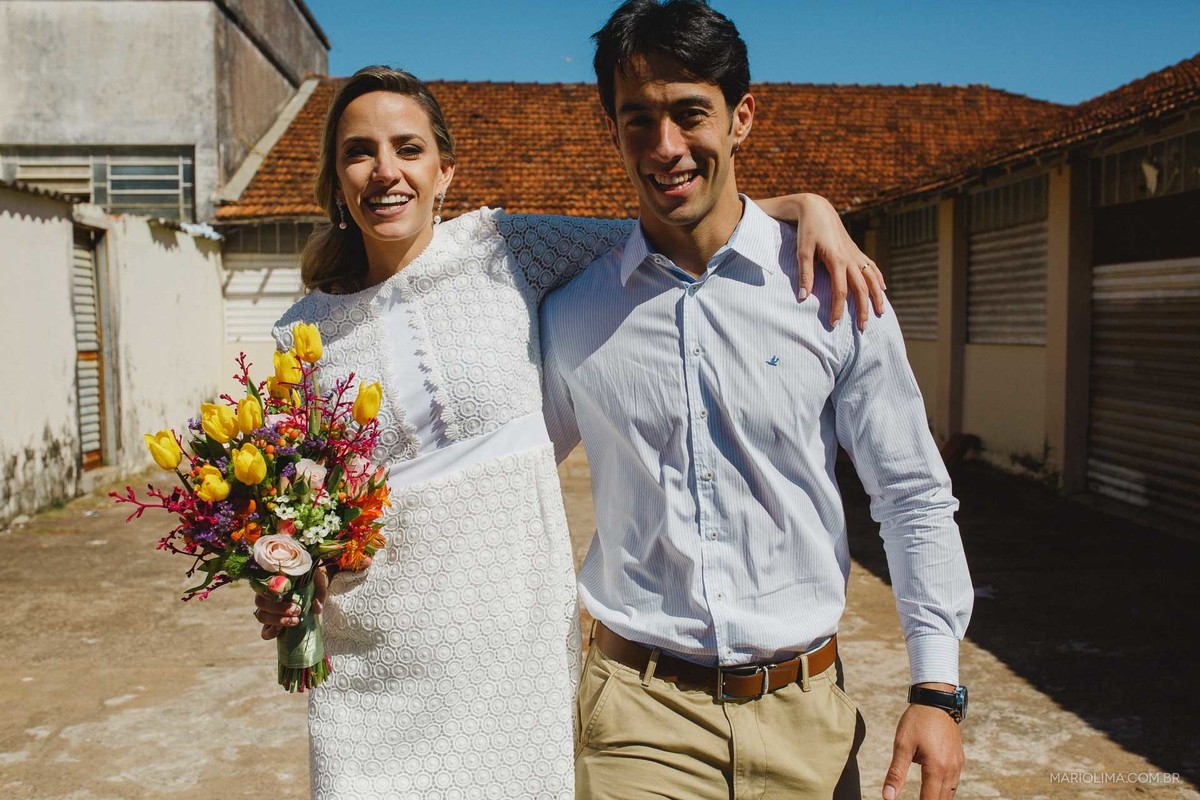 Fotografia de noiva abraçando o noivo e segurando bouquet