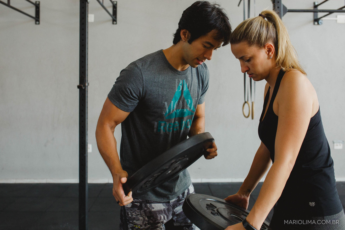 Casal trocando anilhas na Academia de Crossfit