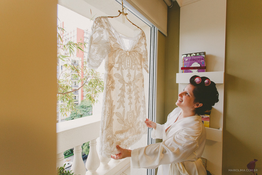 Making of da noiva olhando para o vestido feito por BHLDN