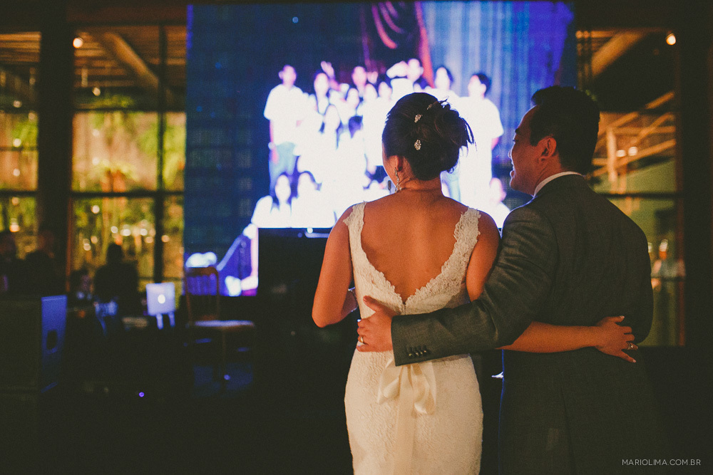 Noivos assistindo a retrospectiva em festa de casamento no Espaço Gardens