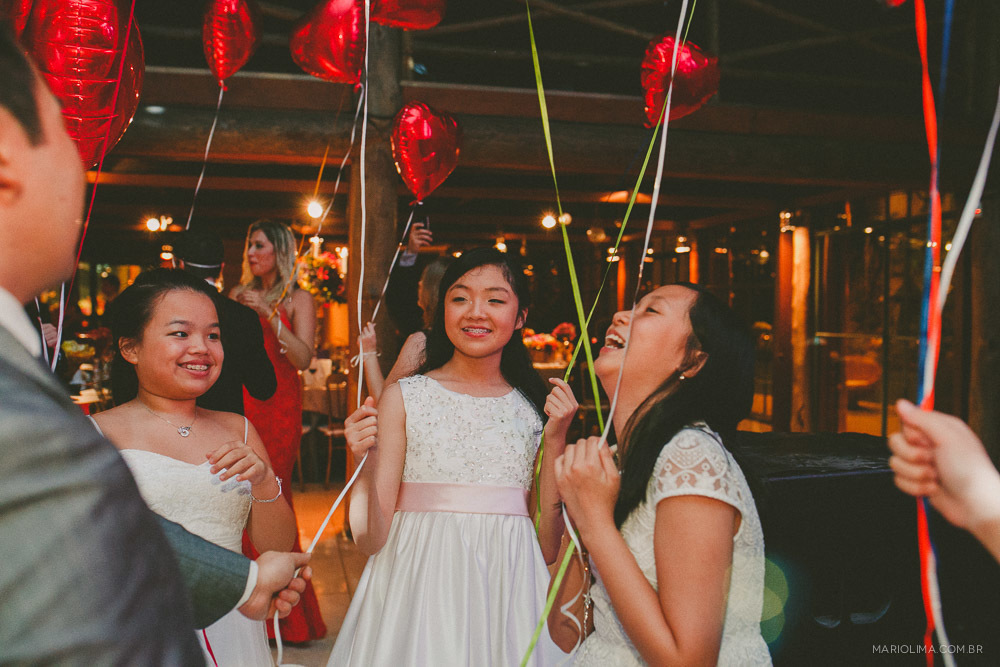 Daminhas segurando bexigas de coração em festa de casamento no Espaço Gardens