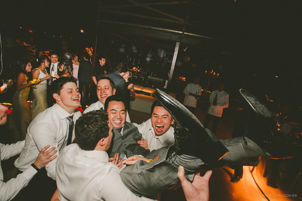 Noivo sendo carregado por padrinhos em festa de casamento no Espaço Gardens