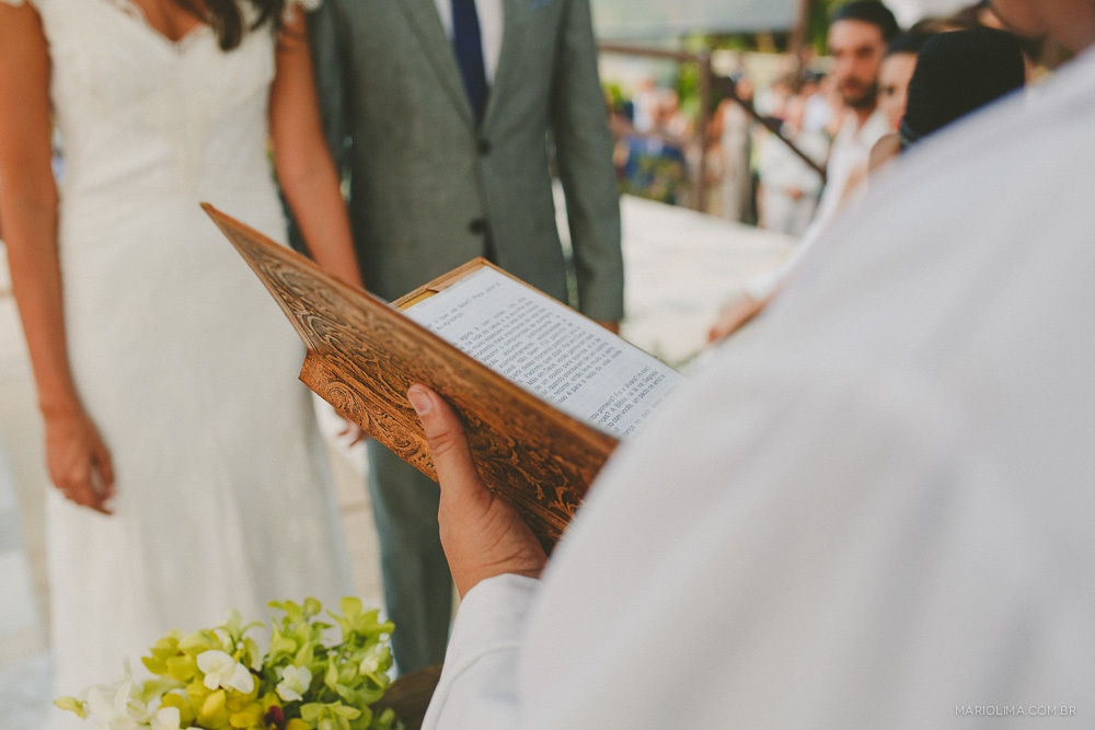 Fotografia de padre segurando a bíblia em cerimônia de casamento no Juquehy