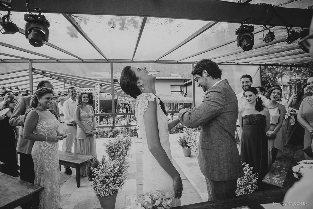 Noivo colocando aliança no dedo da noiva