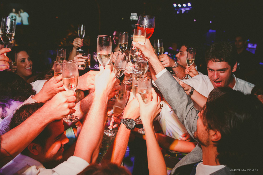 Retrato de brinde dos noivos com os convidados em festa de casamento na praia no Juquehy