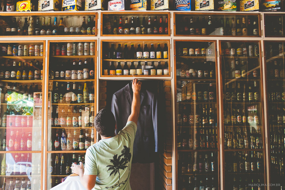 Fotografia de noivo pegando o terno