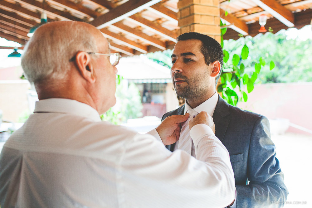 Fotografia de pai arrumando gravata do noivo