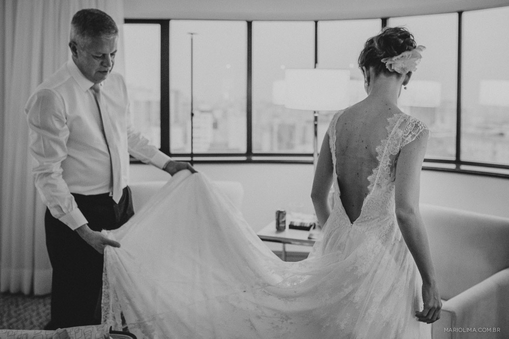 Pai segurando vestido da noiva feito por A Modista