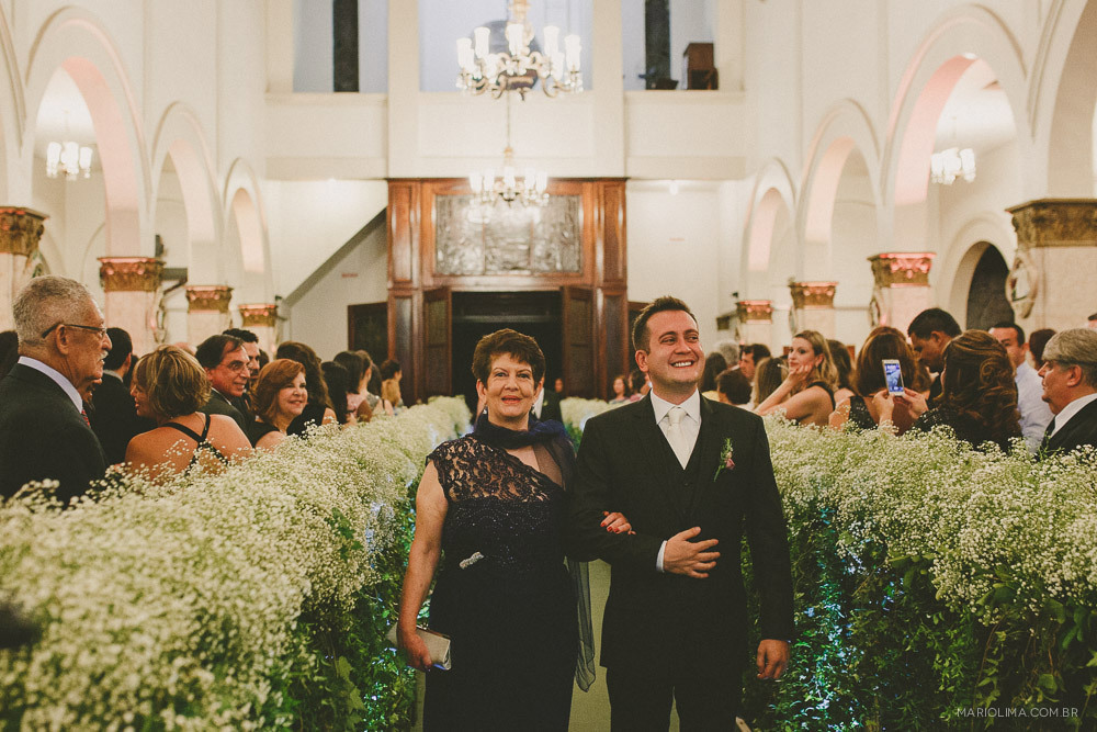 Noivo entrando com a mãe em cerimônia de casamento na Igreja São José do Jardim Europa