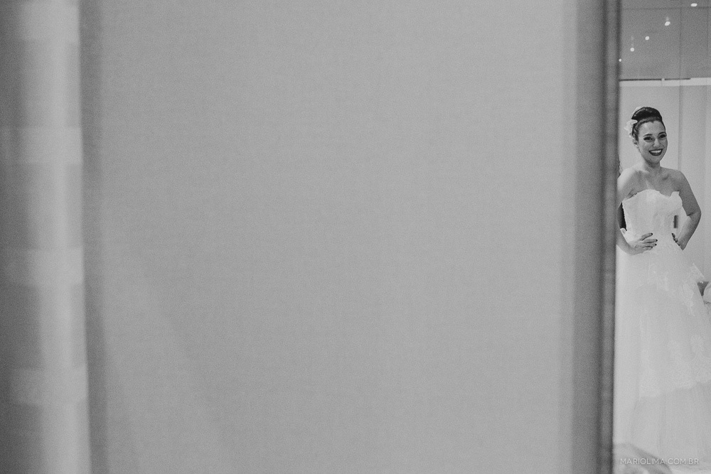 Noiva com vestido de noiva feito por Cymbelline se olhando no espelho