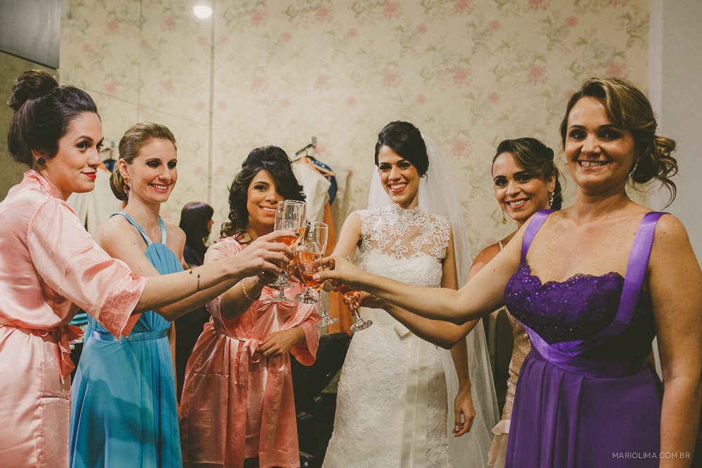 Fotografia de noiva bebendo champagne com as madrinhas