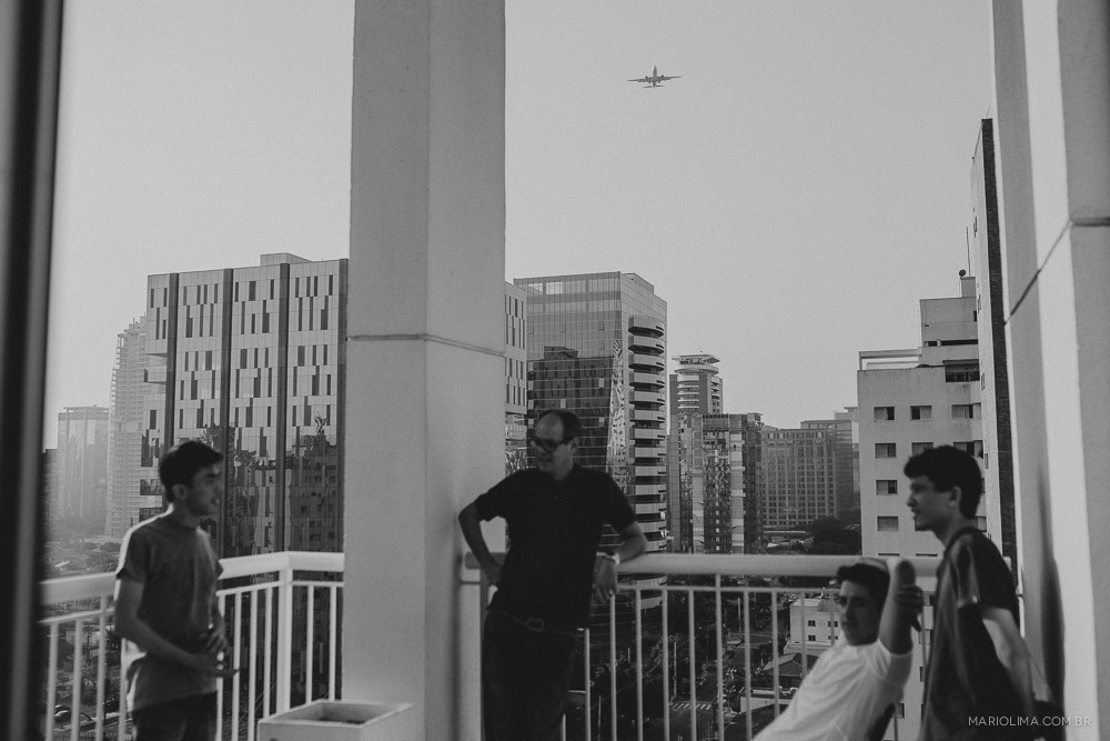 Noivo conversando na sacada com os padrinhos