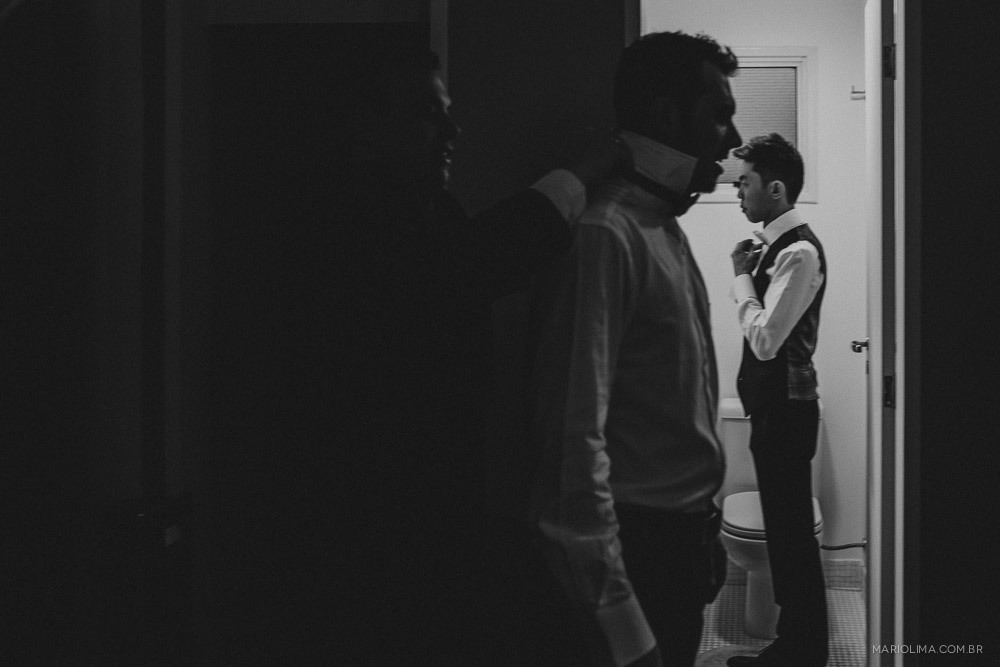 Fotografia de noivo se arrumando para o casamento com os padrinhos