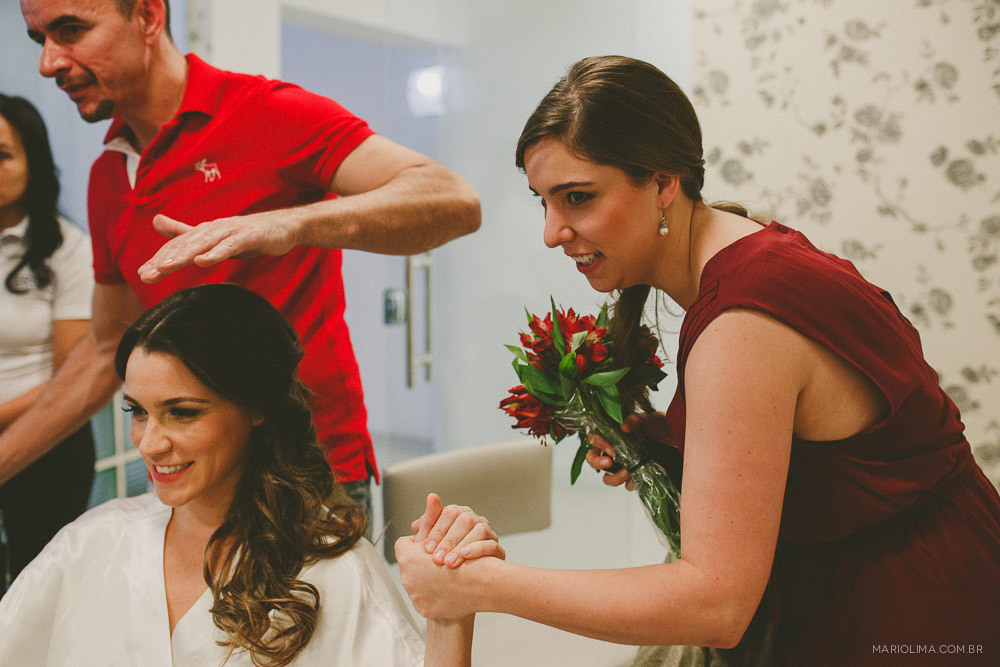 Madrinha segurando o bouquet e a mao da noiva no making of