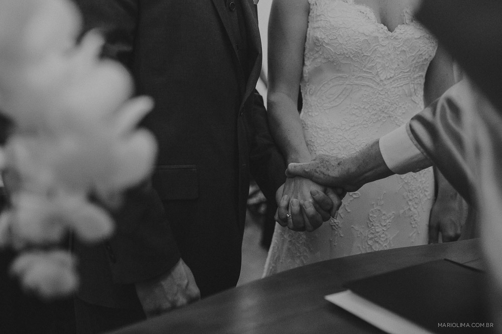 Padre segurando a mao dos noivos em cerimônia de casamento no Studio Carlota