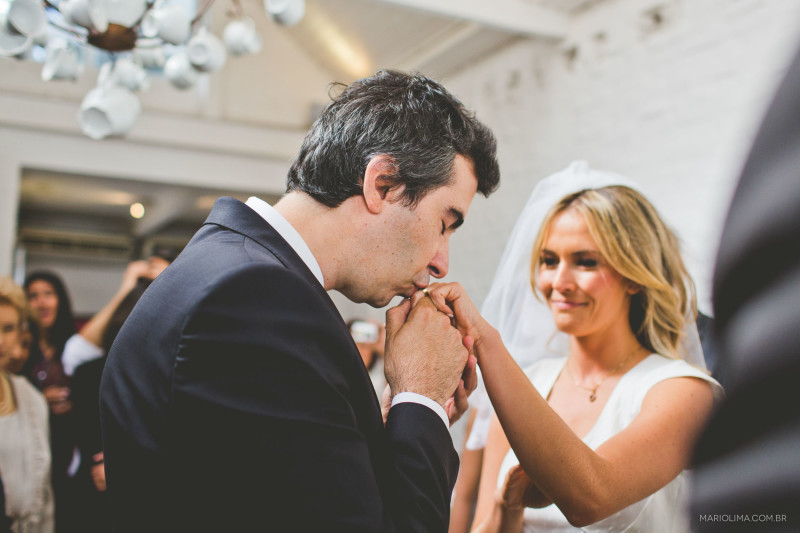 Noivo beijando a mao da noiva em cerimônia de casamento no Studio Carlota