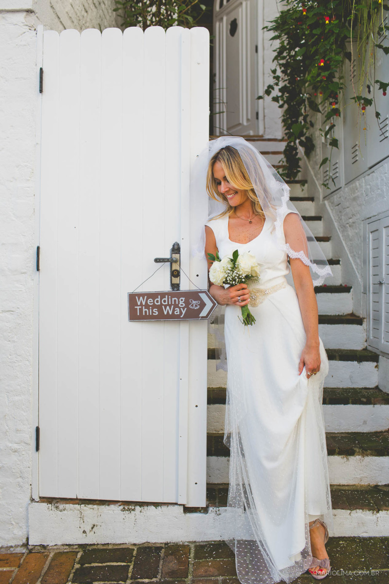 Fotografia de noiva perto da placa decorativa e segurando bouquet feitos por D. Filipa e Coisas de Doris