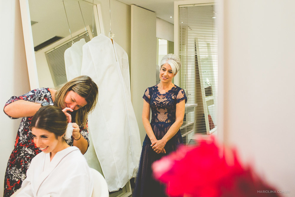 Mae olhando a equipe do L´Officiel III arrumar o cabelo da noiva