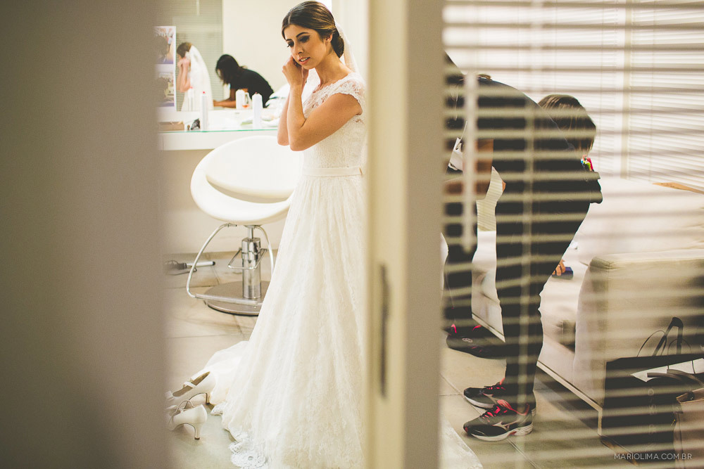 Fotografia de noiva colocando os brincos da Swarovski 