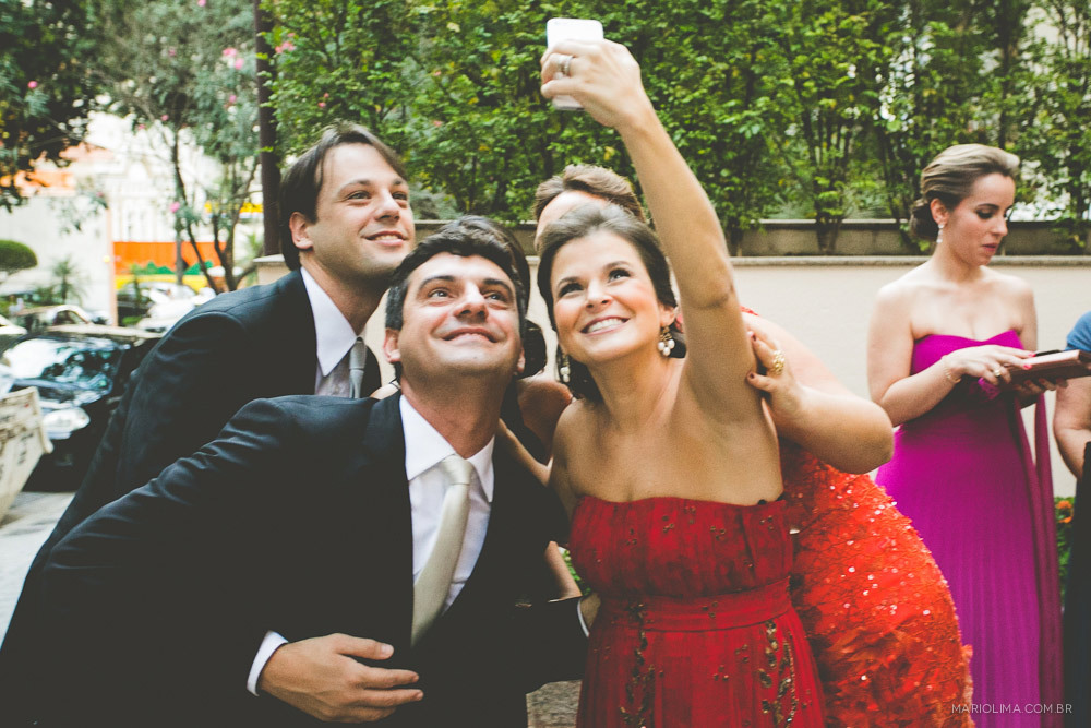 Fotografia de madrinha tirando foto com o noivo
