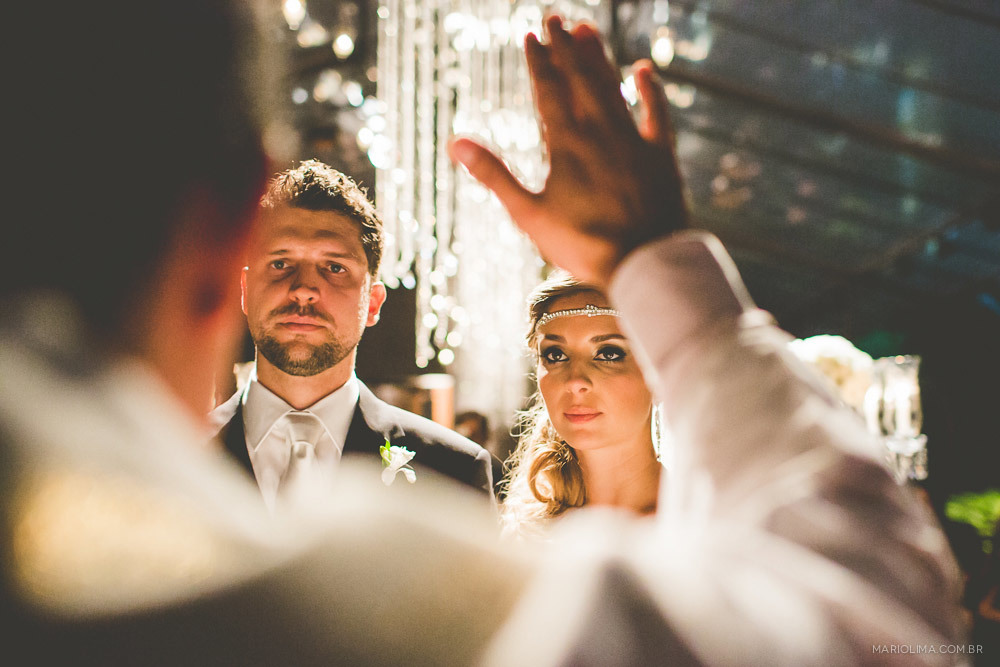 Padre abençoando os noivos em cerimônia de casamento na Traffô Eventos