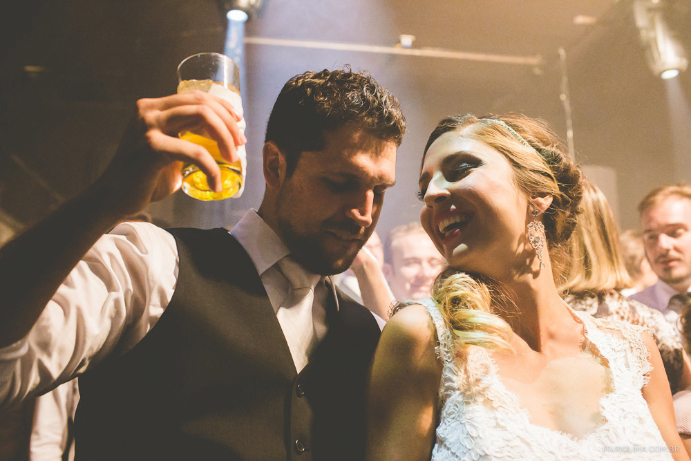 Noivo bebendo e noiva sorrindo em festa de casamento na Traffô Eventos