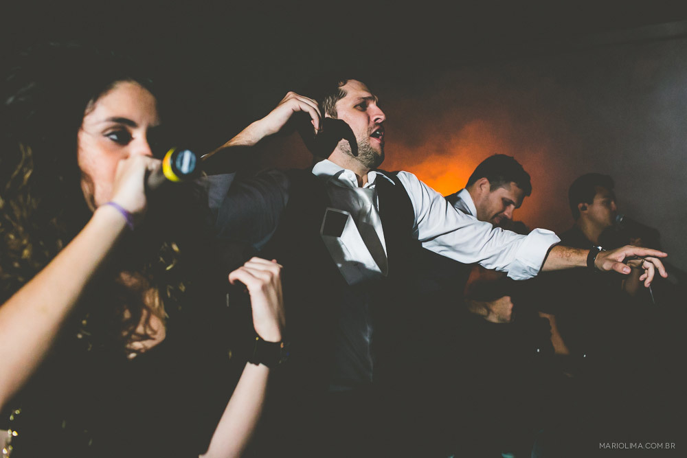 Fotografia de noivo dançando e madrinha bebendo em festa de casamento na Traffô Eventos